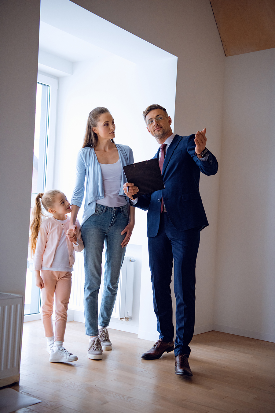 Handsome broker showing a room to a single mother and child, representing agents saving clients thousands with an attorney opinion letter.